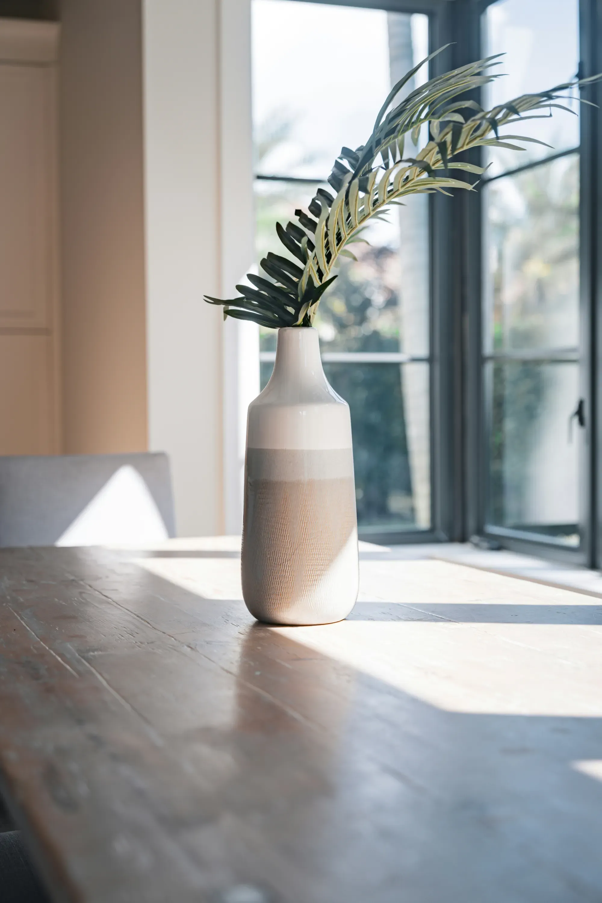 Sunlit interior entryway featuring a decorative tall vase.