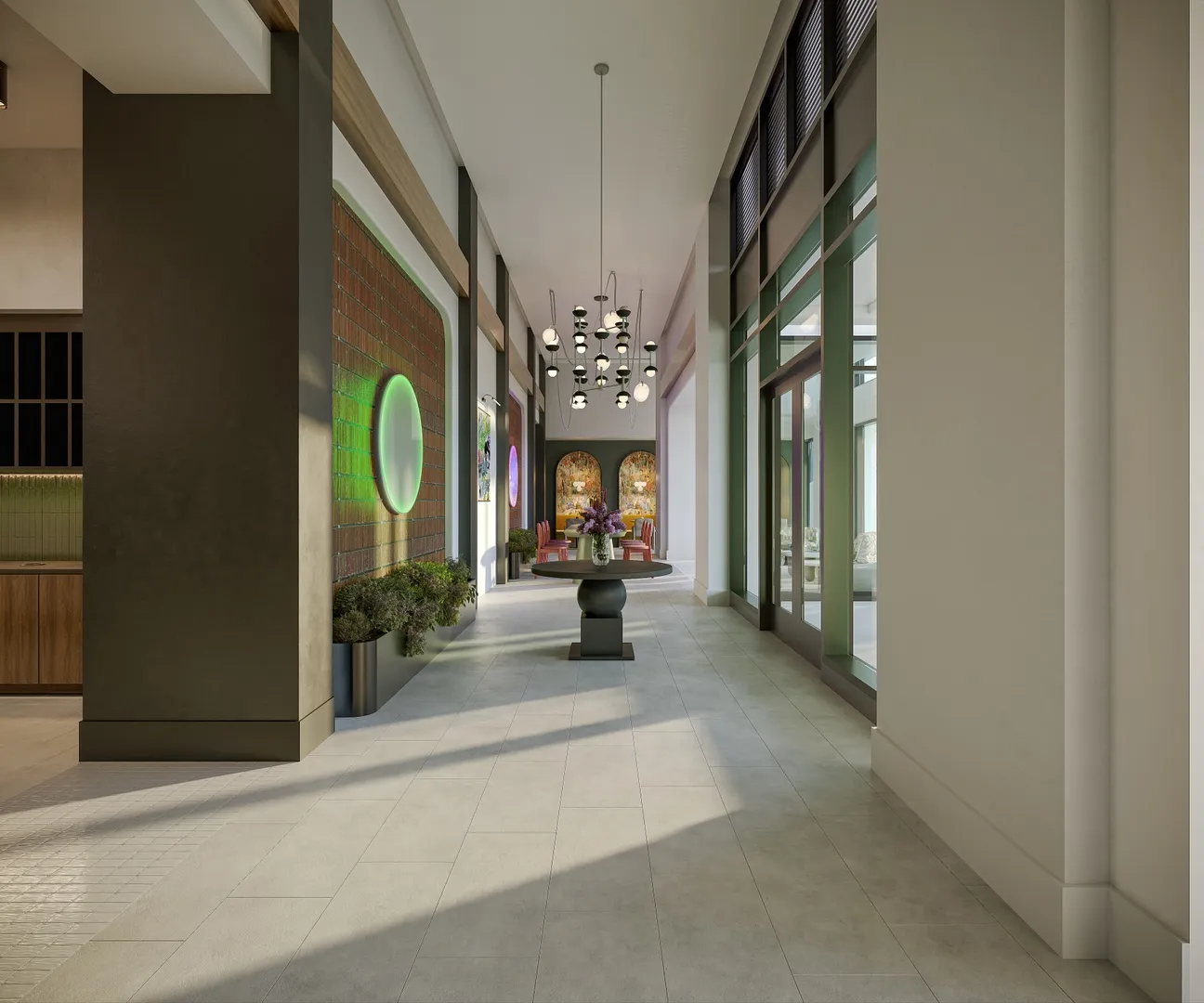 Bright, modern hallway with a dark accent wall, green circular mirror, floral centerpiece under hanging lights, and large windows opening to the outdoors.