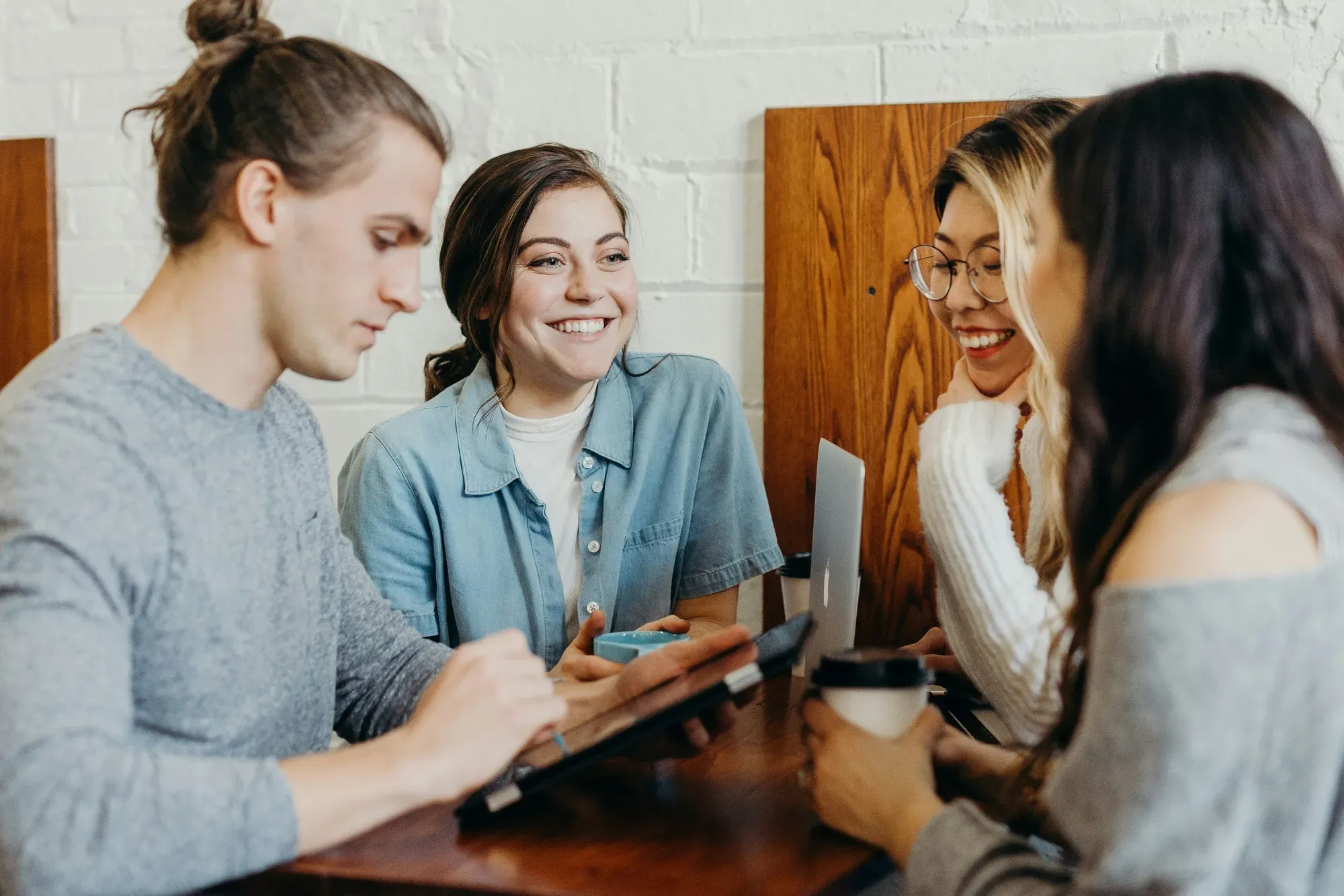 Group of coworkers discussing and looking at a tablet together