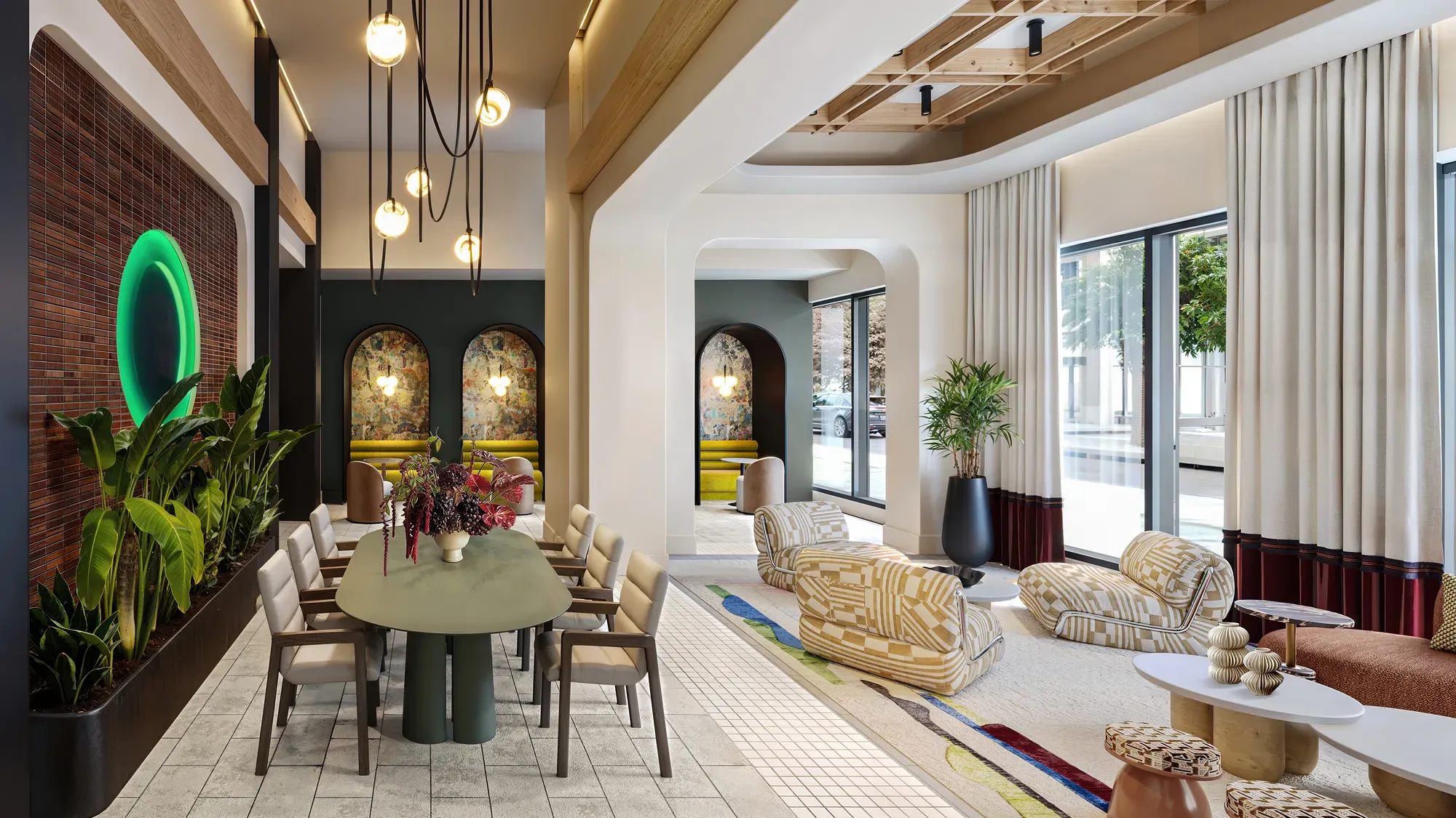 Stylish modern building lounge featuring a dining table, pendant lighting, and comfortable seating areas.